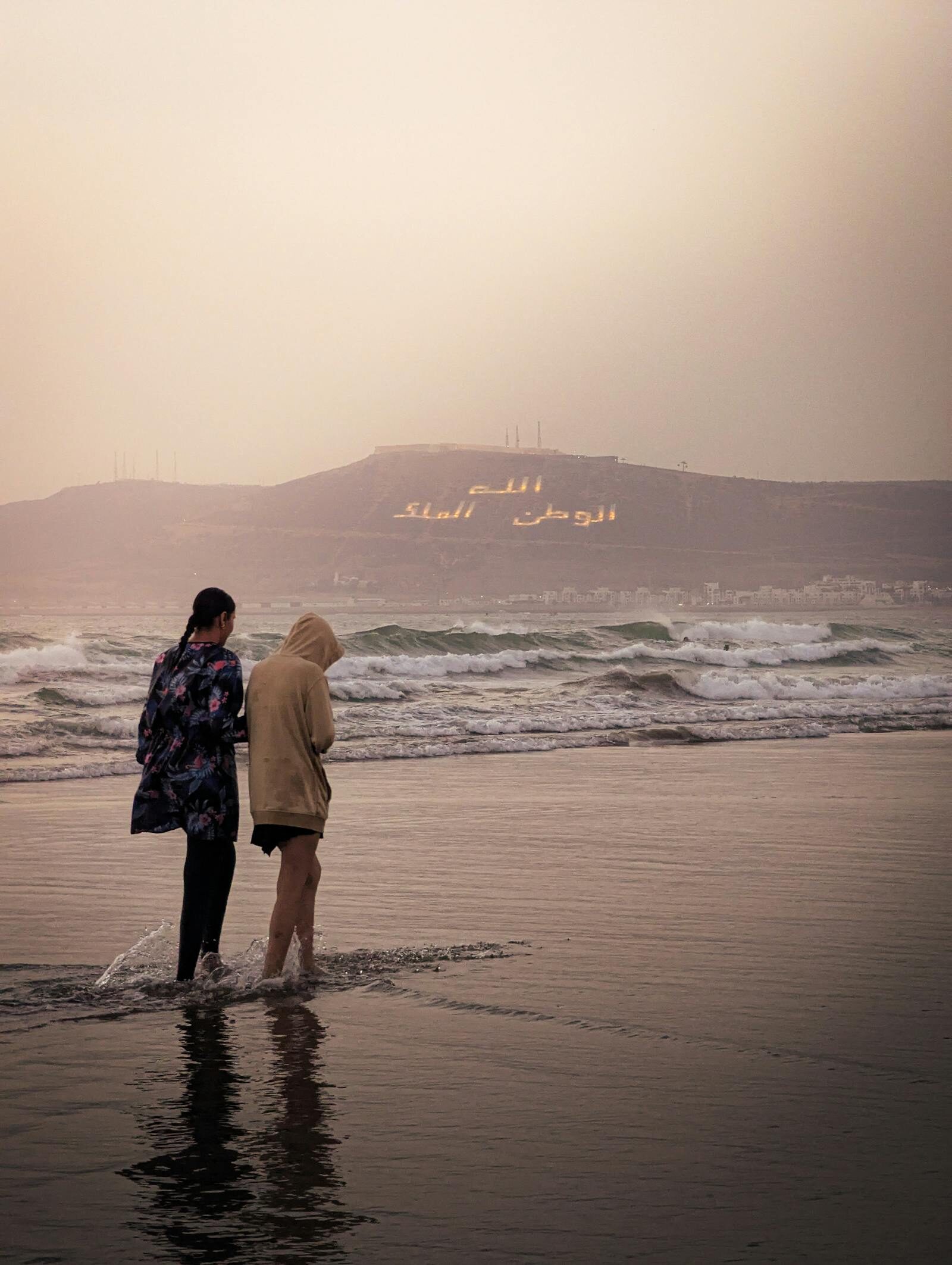 Couple walking the Agadir corniche promenade at sunset, Morocco