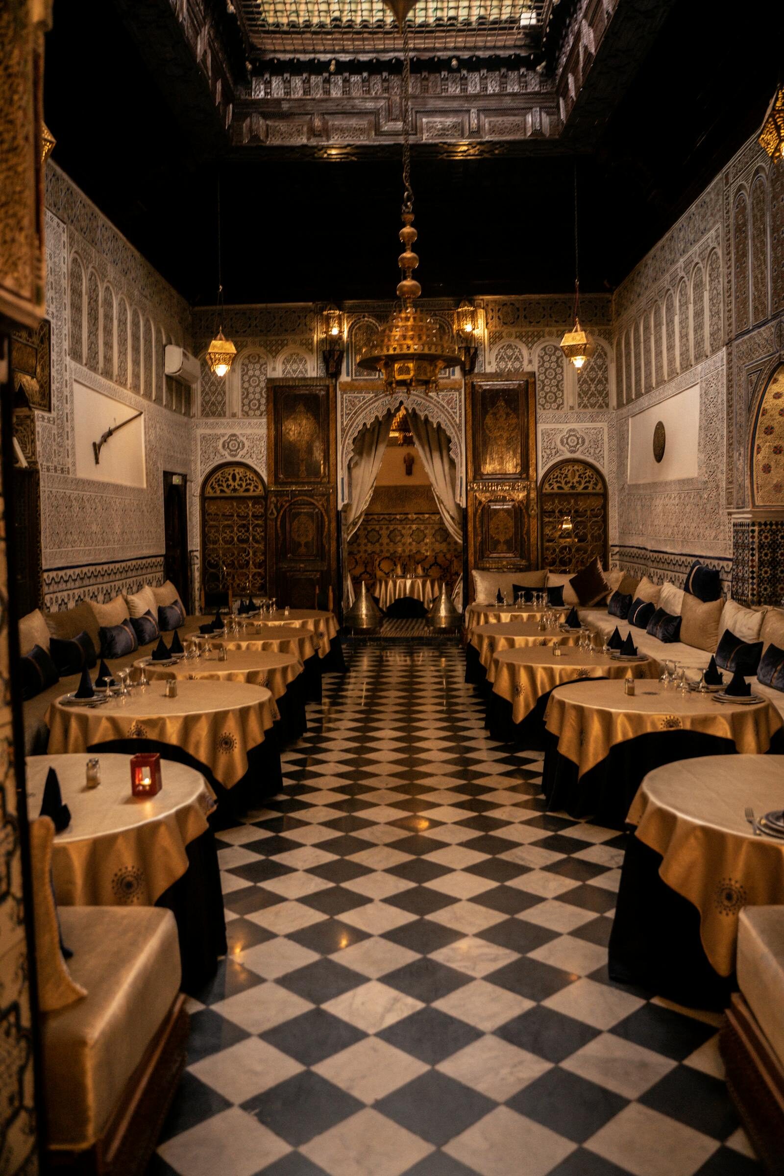Moroccan-Mediterranean restaurant interior with green and wood tones, communal tables