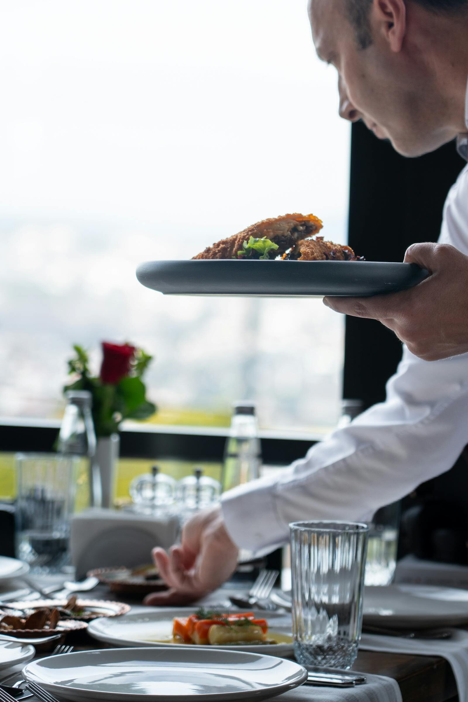 Restaurant staff hands serving and setting a table