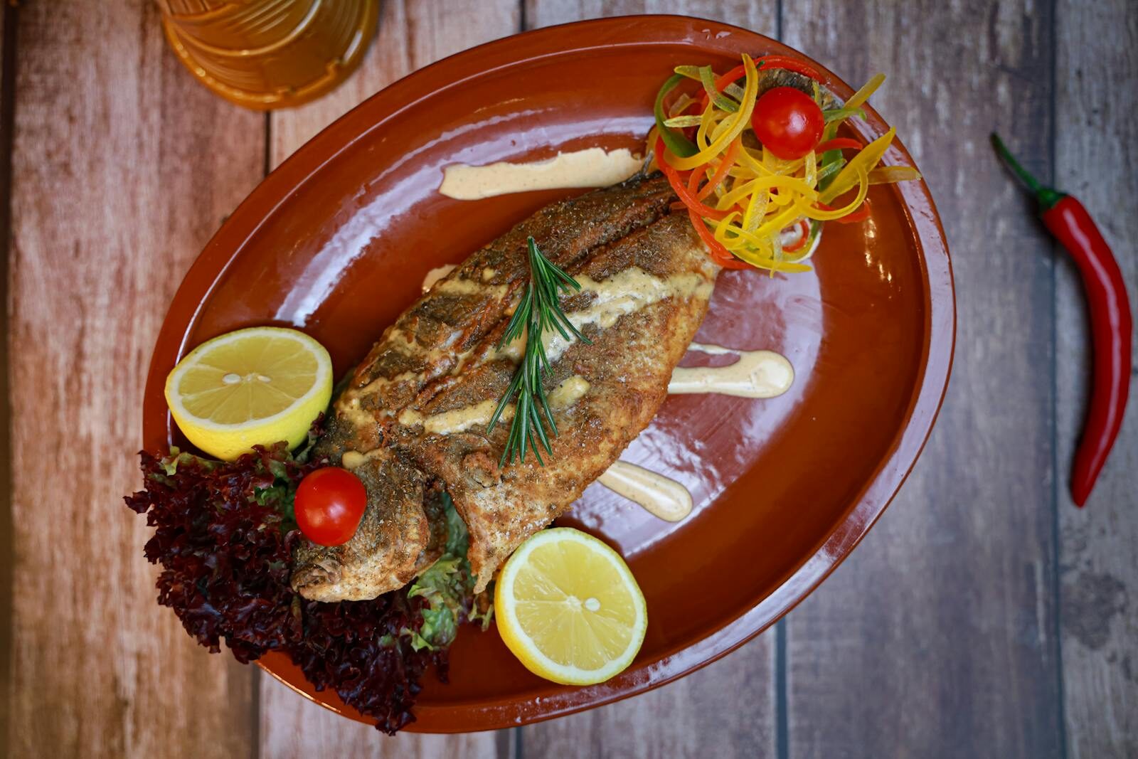 Whole grilled sea bass plated with herbs and lemon at Les Blancs Agadir