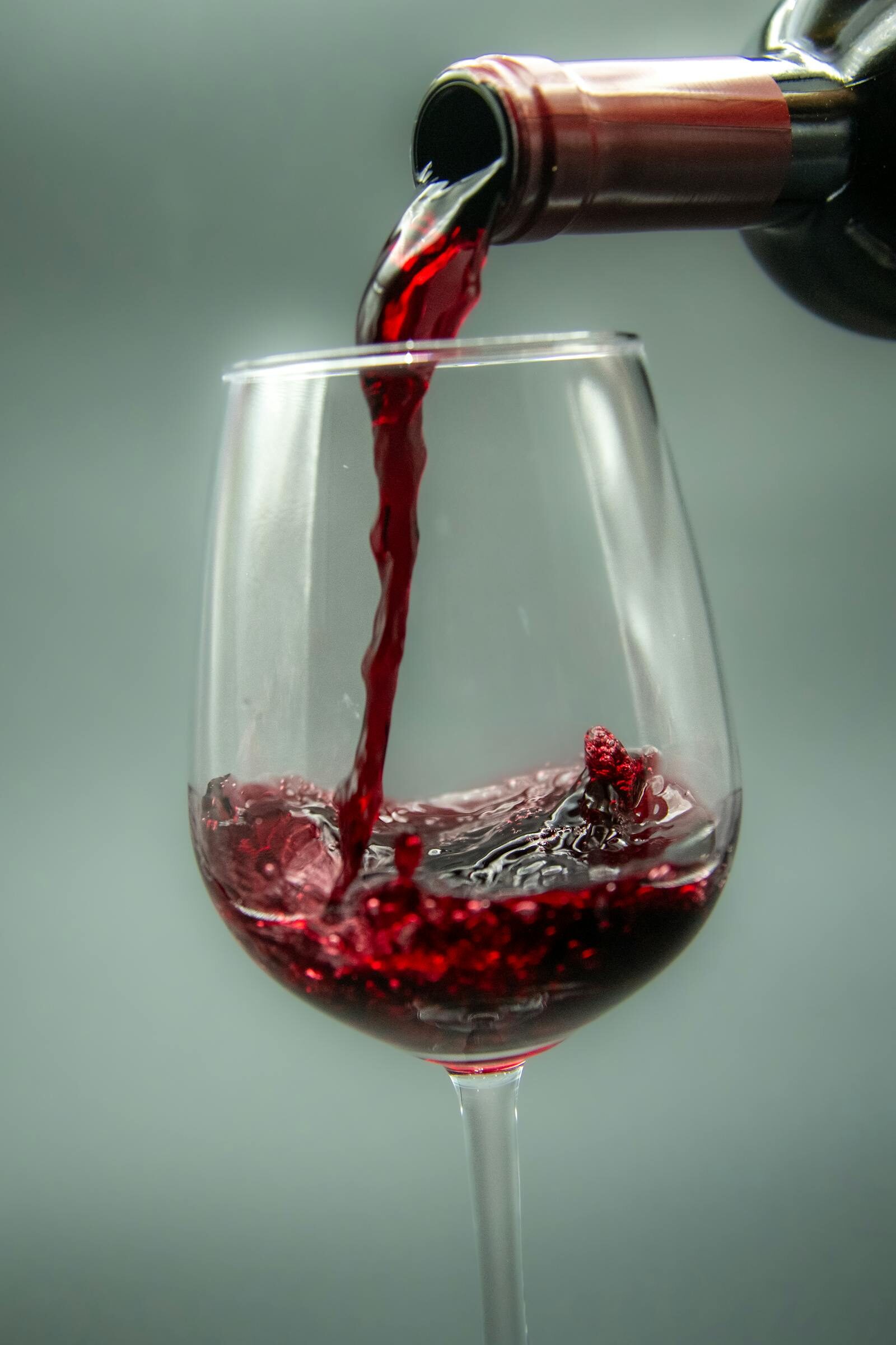 Wine being poured into a glass at a candlelit table on the Les Blancs Agadir terrace