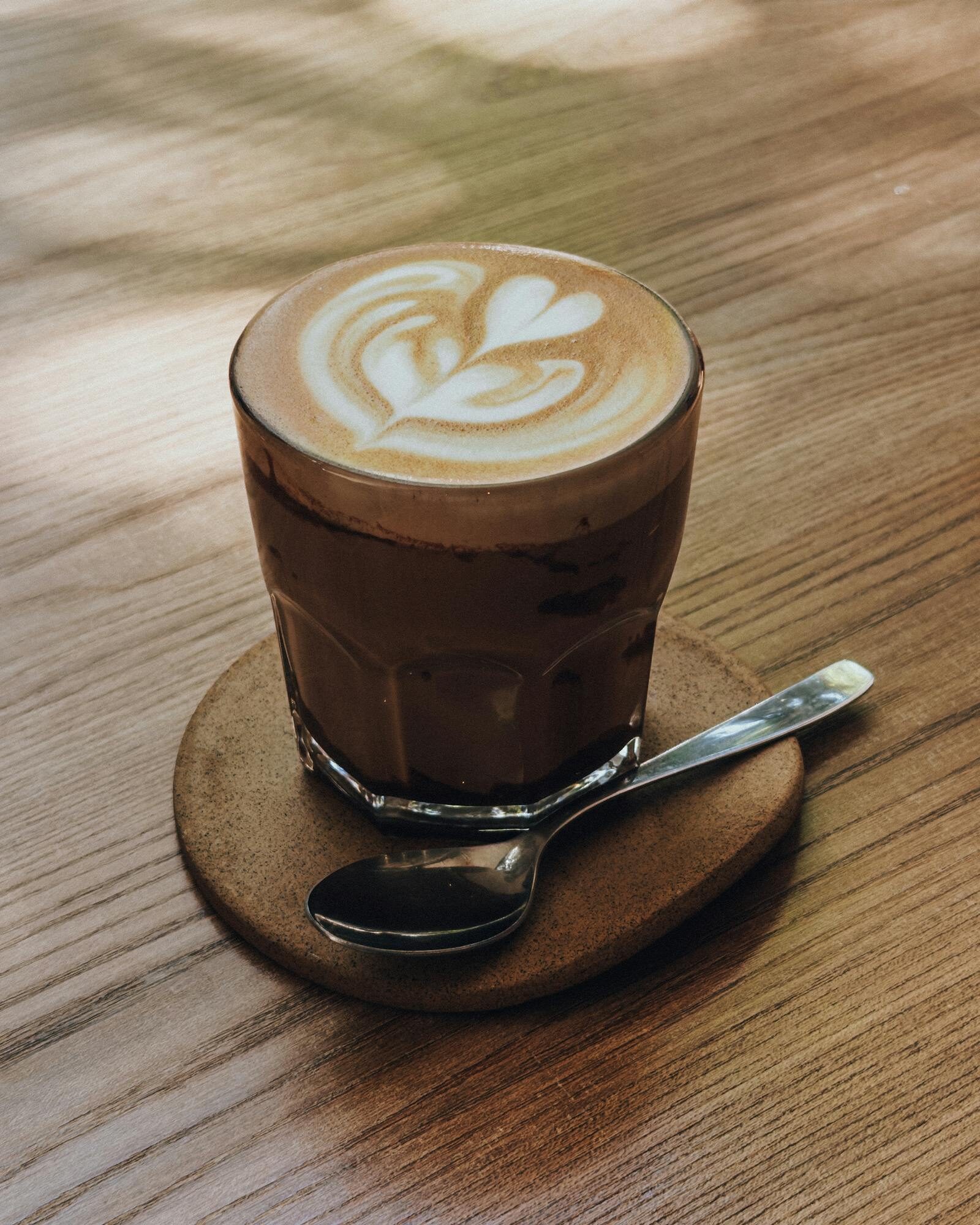 Flat white coffee with latte art on a wooden table at Restaurant TamTam brunch Agadir