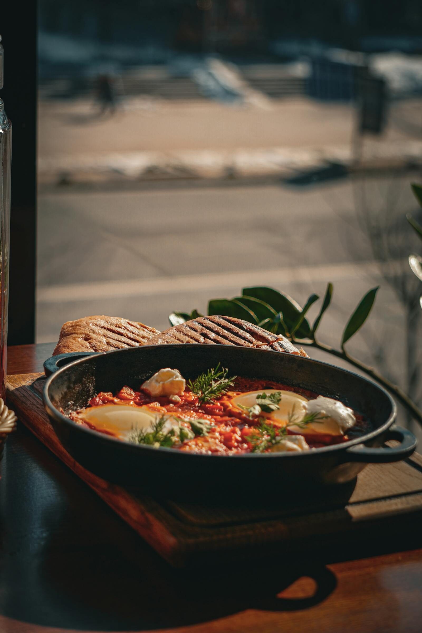 Shakshuka eggs cooked in a skillet by a sunlit window, a brunch favourite at TamTam Agadir