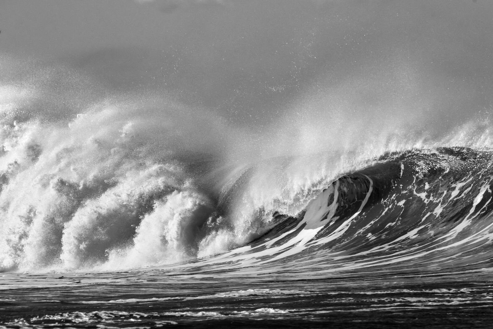 Solid winter Atlantic swell breaking with heavy spray, head-high and stacked