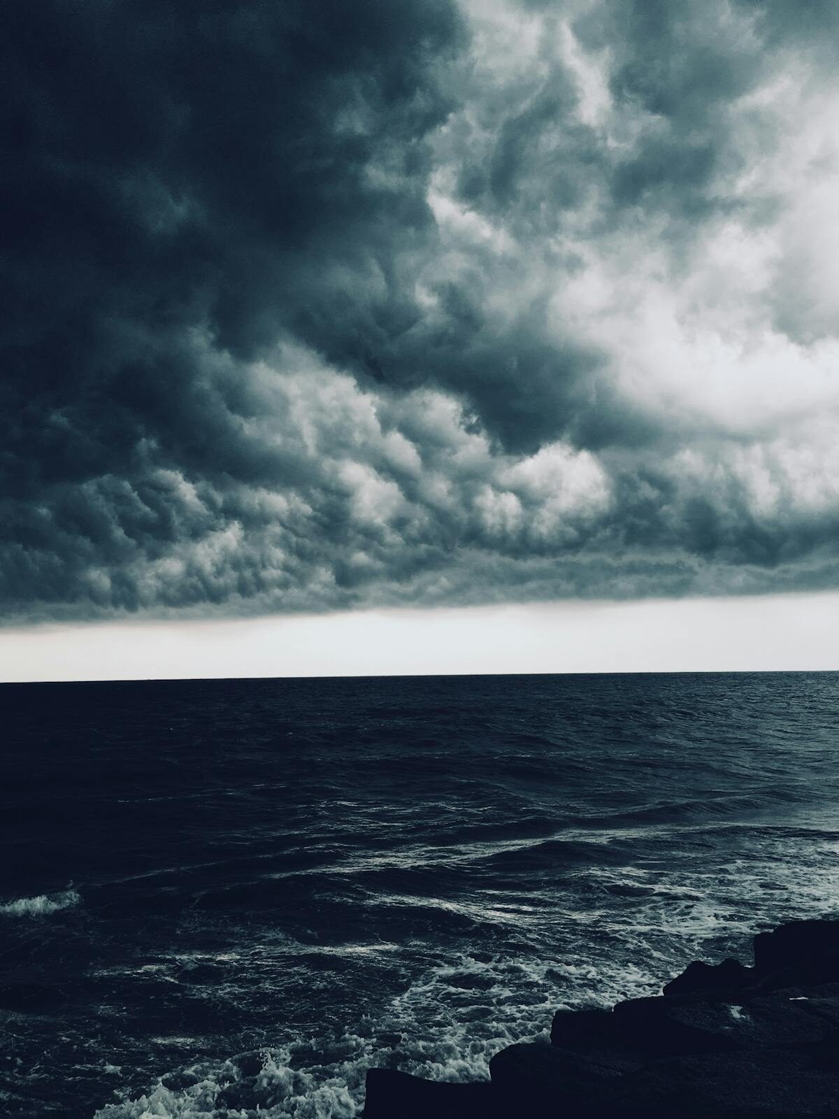 Atlantic coast under a heavy storm sky, churning sea and dark clouds
