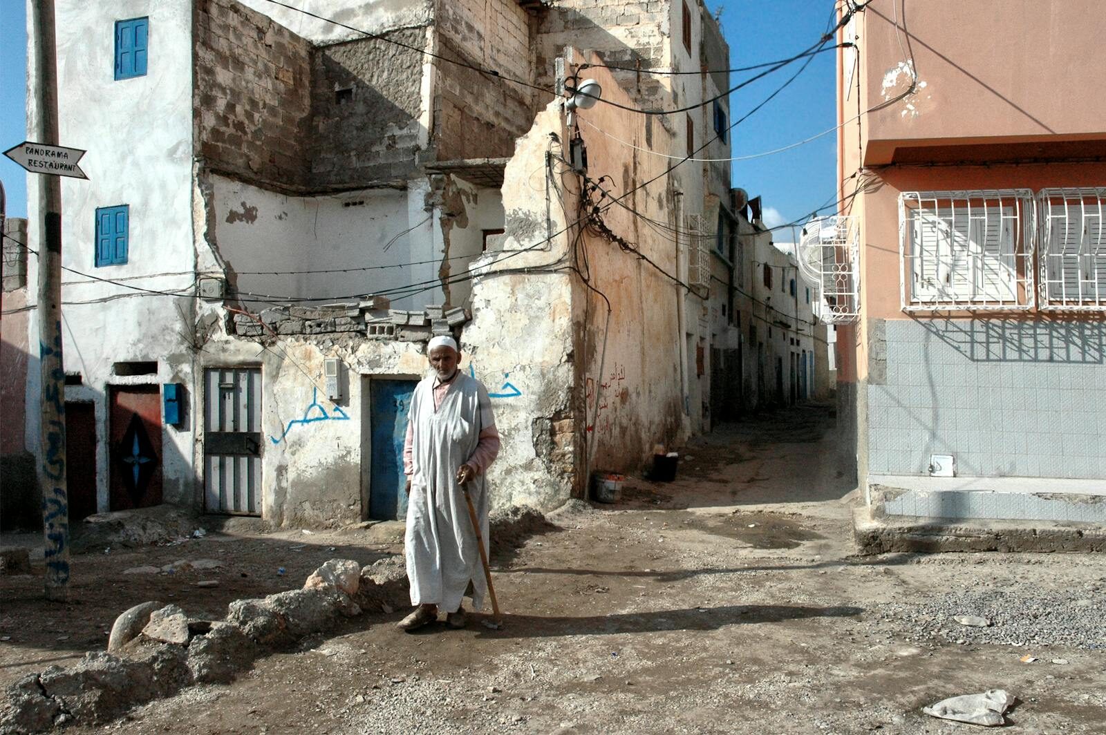 Narrow whitewashed streets of Taghazout village with palms and walls