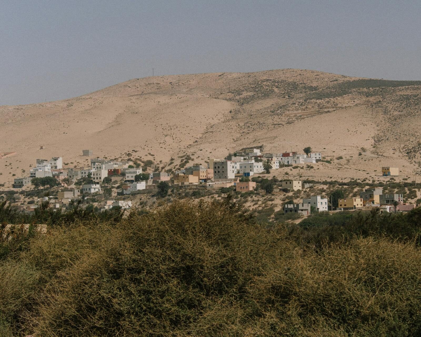 Aerial view of a Moroccan coastal village on a hillside surrounded by arid landscape
